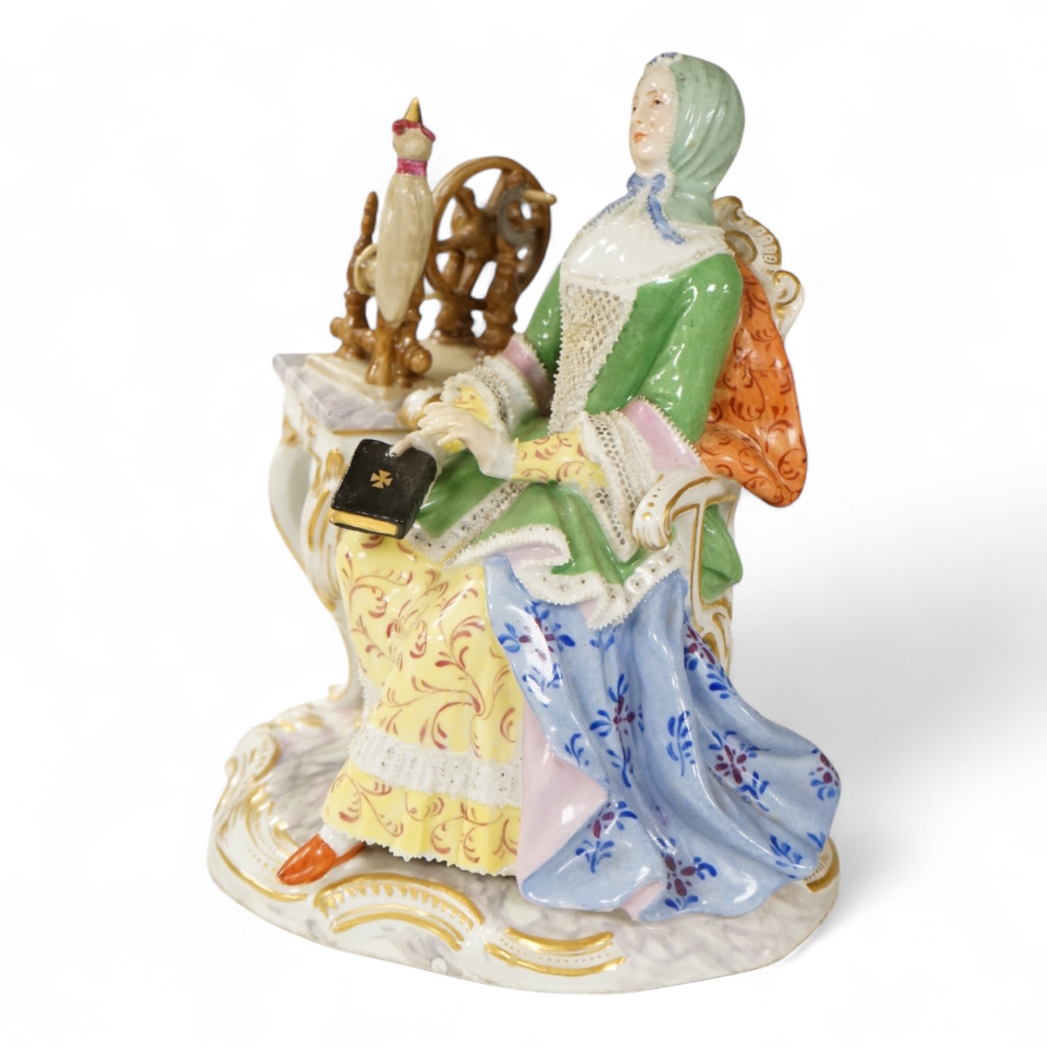 A Meissen style figure of a seated lady at her spinning wheel, 15.5cm high.